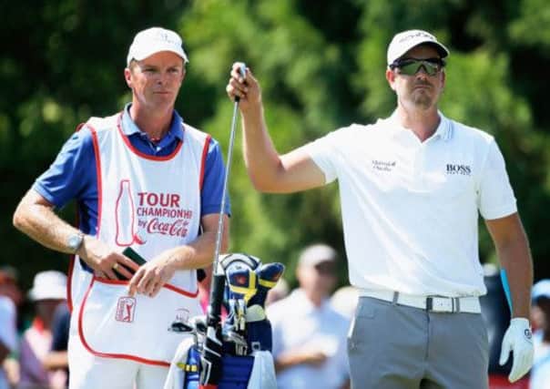 Henrik Stenson takes a club from the bag of his caddie Gareth Lord during the Tour Championship first round in Atlanta. Picture: Getty