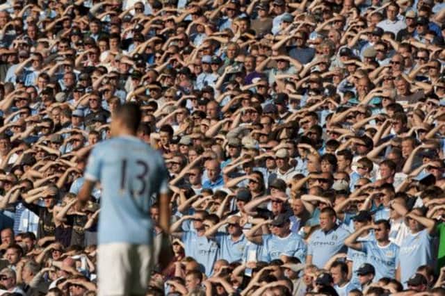 Manchester City fans shield their eyes on a day when Sergio Aguero scored twice to ensure a dismal day for David Moyes. Picture: AP
