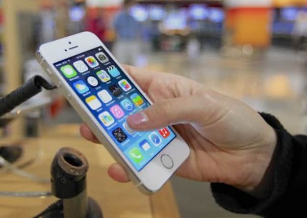 A customer examines a display version of the new iPhone 5s, displaying a mock-up of the new iOS7. Picture: AP