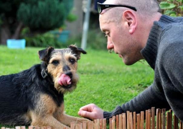 Roxi the Lakeland terrier back at home with owner Barry Mullins after being rescued by firefighters, in Elgin, Moray. Picture: Hemedia