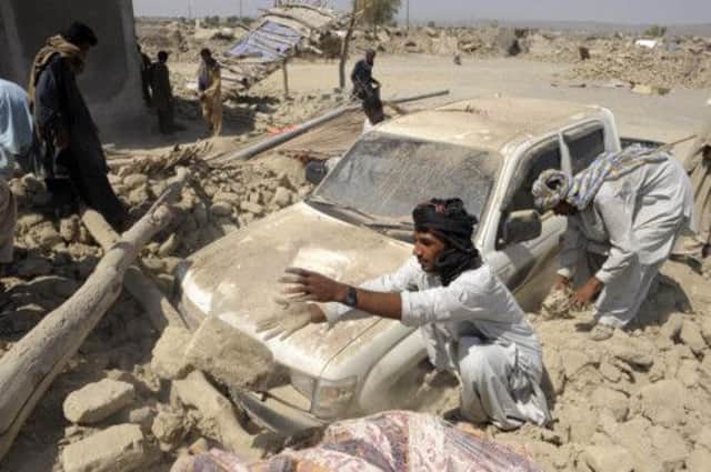 Survivors in Awaran begin to clear the debris of their homes, destroyed by Tuesdays earth quake. Picture: Getty