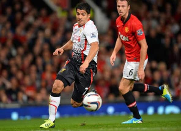 Liverpool's Luis Suarez vies with Manchester United defender Jonny Evans last night. Picture: AFP