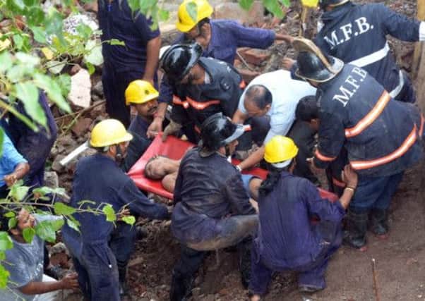 Firefighters and rescue workers bring out a survivor. Picture: AFP