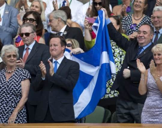 First Minister  Alex Salmond  celebrates with a Saltire after Andy Murray's victory in the Wimbledon final. Picture: SNS