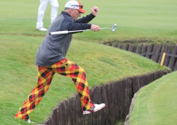 Sir Ian Botham jumps across a burn on the third hole at Carnoustie. Picture: Jane Barlow