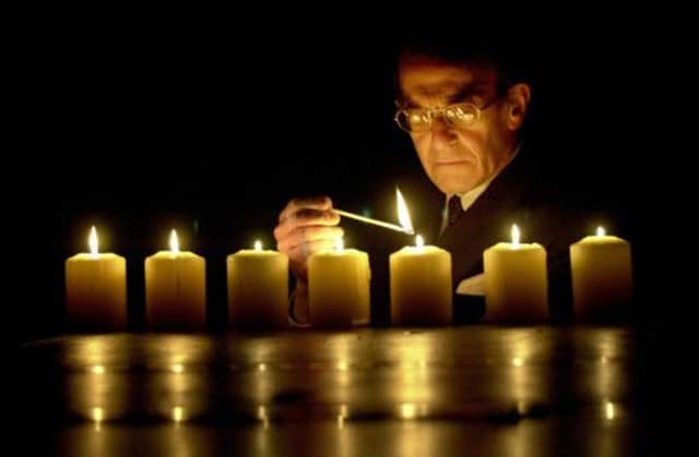 The Rev Ernest Levy lights memorial candles at The Usher Hall in 2001, in memory of those who died in all genocides. Picture: Colin Hattersley