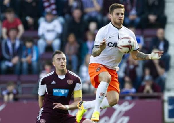 David Goodwillie gets on the ball ahead of Hearts' Danny Wilson. Picture: SNS