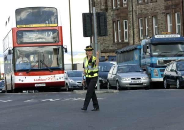 A police traffic warden diverts vehicles in Edinburgh. Picture: Greg Macvean