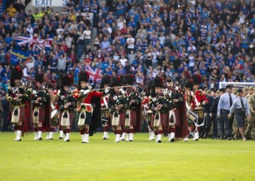 Armed Forces members take to the field at Ibrox. Picture: SNS