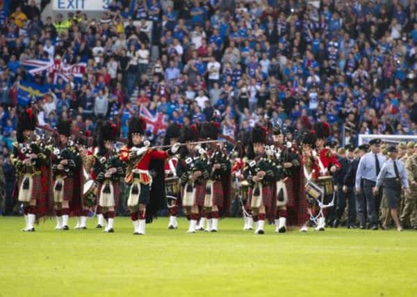Armed Forces members take to the field at Ibrox. Picture: SNS