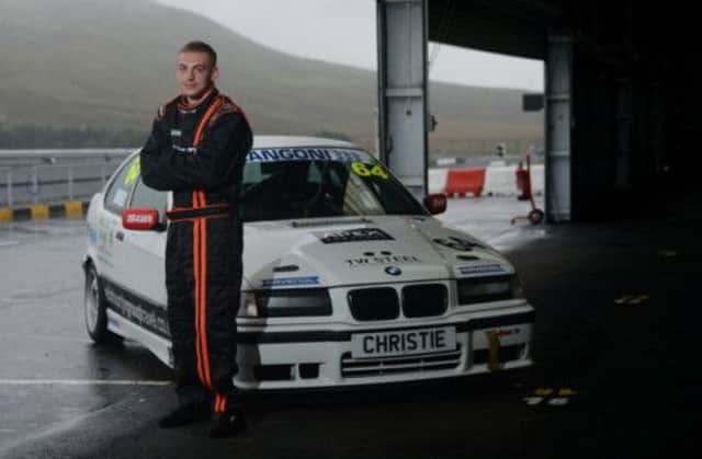 Davie Birrell at a rainy Knockhill circuit alongside the BMW Compact racing car he will be competing in. Picture: Neil Hanna