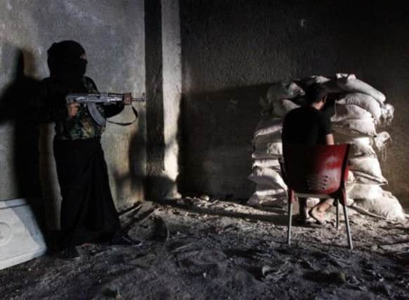 FSA fighters take cover in an Aleppo suburb. Picture: Reuters