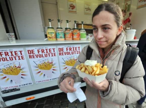A young Belgian makes sure she has plenty of mayo on her meal on chips revolution day  celebrating the national dish. Picture: Getty
