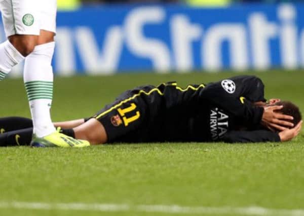 Barcelona's Neymar lies in 'agony' on the Parkhead pitch after a kick from Scott Brown which led to the Celtic captain being red-carded. Picture: AP