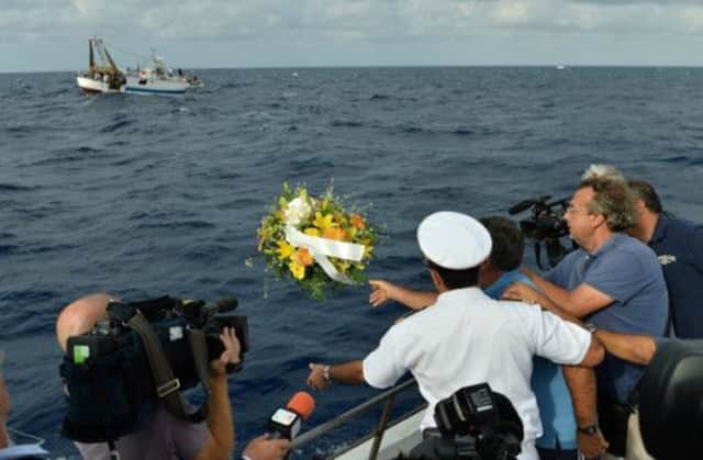 Fishermen from Lampedusa throw a wreath into the sea at the site of the sinking. Picture: Getty