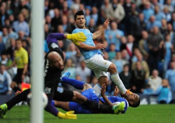 Sergio Aguero shoots past a grounded Sylvain Distin and keeper Tim Howard for the second goal. Picture: Getty
