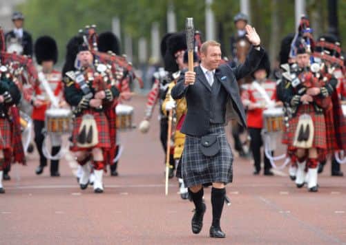 Sir Chris Hoy carries the Commonwealth Games baton towards Buckingham Palace in London. Picture: Getty