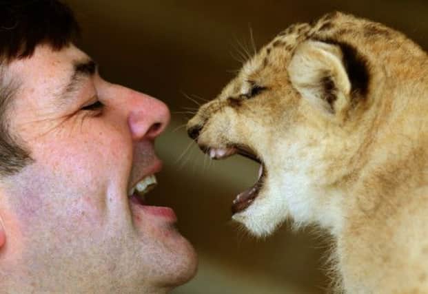 Karis, a one month old lion cub, with head keeper Brian Reid. Picture: PA