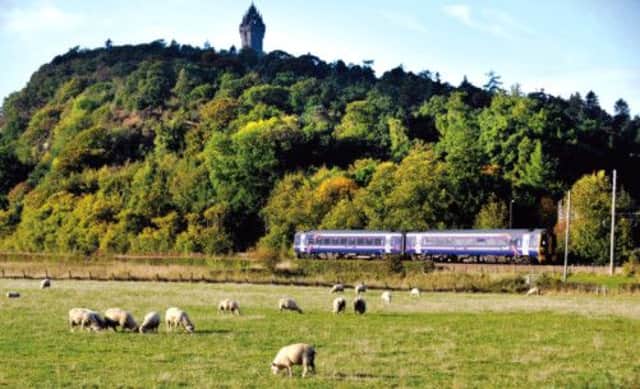 A ScotRail train between Alloa and Stirling runs past the Wallace Monument  the route may need £17m of essential repairs. Picture: Phil Wilkinson