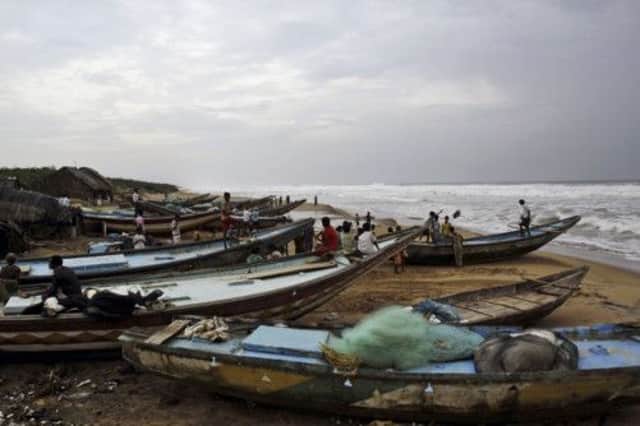 Fishermen scan the horizon for signs of the approaching cyclone Phailin on the coast on the Bay of Bengal. Picture: AP
