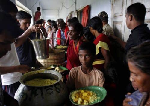 Evacuated Indian villagers eat food at a temporary cyclone shelter in Chatrapur in Ganjam district. Picture: AP