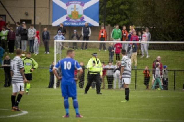 A pitch invasion, complete with smoke bombs, brought the action to a halt at Pennypit Park. Picture: Malcolm McCurrach