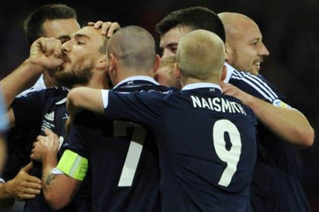 Robert Snodgrass is mobbed after opening the scoring for Scotland. Picture: Phil Wilkinson
