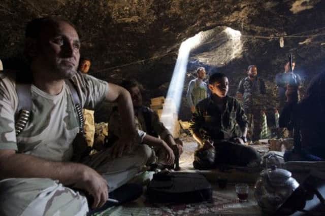 Free Syrian Army fighters take a break in the safety of a cave. Picture: Reuters