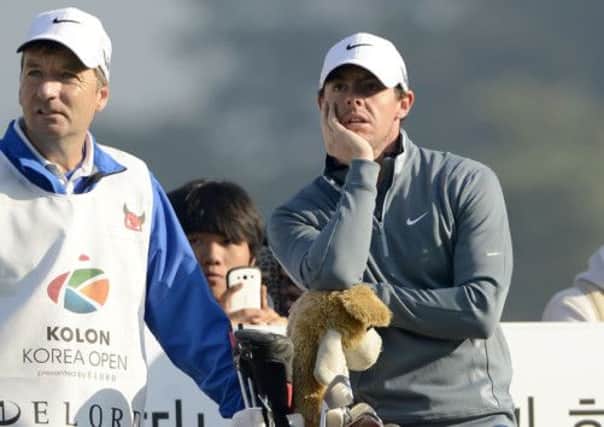 Rory McIlroy stands with his caddy, JP Fitzgerald, at the 14th tee, the start of a run of bogeys. Picture: AP
