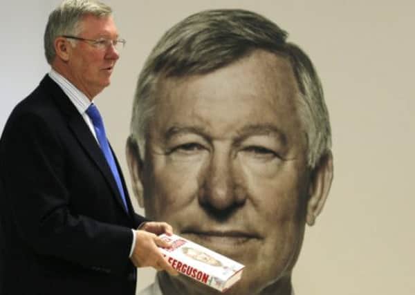 Former Manchester United manager Alex Ferguson poses with his new autobiography. Picture: Reuters