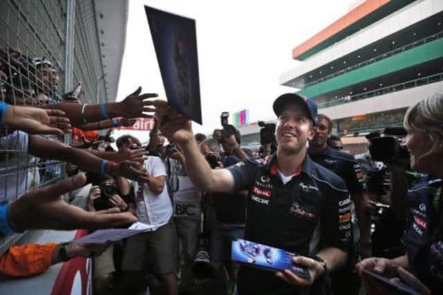 Sebastian Vettel hands out signed copies of his photograph after two flawless practice sessions at the Buddh International Circuit.  Picture: AP