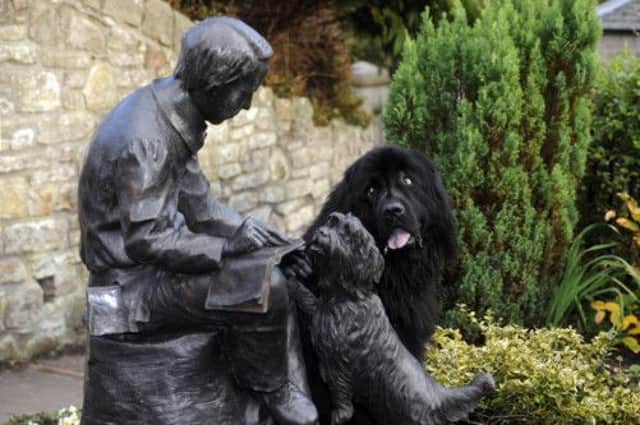 Paddy the Newfoundland has a look at the statue of Robert Louis Stevenson. Picture: Greg Macvea