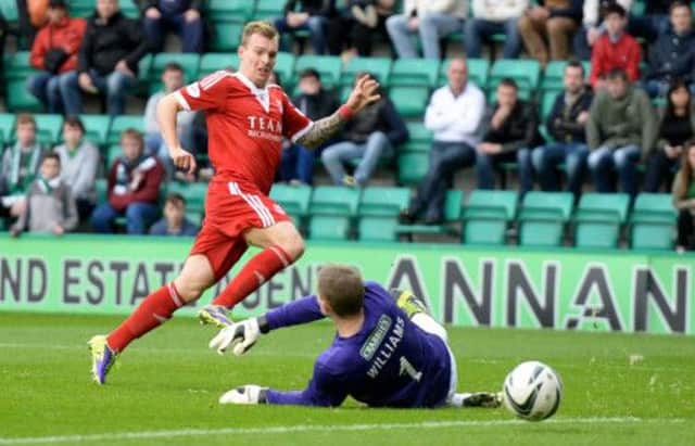 Gregg Wylde slips the ball past Ben Williams to seal Aberdeen's win. Picture: SNS