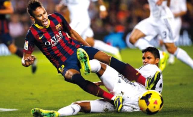 Neymar grimaces as he clashes for the ball with Real Madrid's Raphael Varane. Picture: Getty