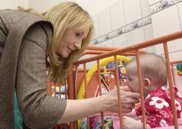 JK Rowling smiles at Maria Dinescu during a visit to the maternity ward of a hospital in Romania, in January 2006. Picture: AP