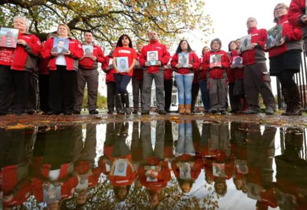 Red Cross volunteers hold pictures of 22 of their colleagues who have been died helping people in Syria. Picture: PA