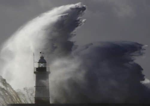 Waves crash against a lighthouse at Newhaven in South East England. Picture: Reuters