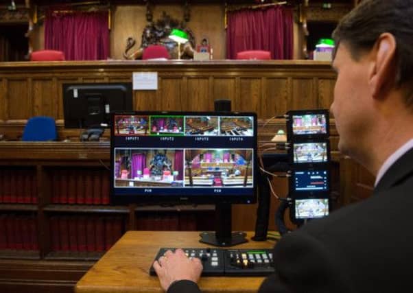 A man checks the monitors from cameras in Court Four at the Royal Courts of Justice in London. Picture: PA