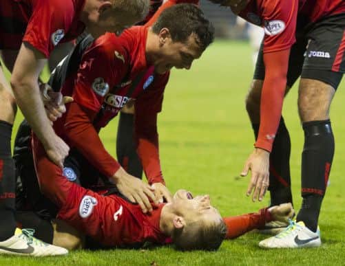 St Johnstone's Gary McDonald (bottom) is mobbed by teammates as they celebrate his winning goal. Picture: SNS