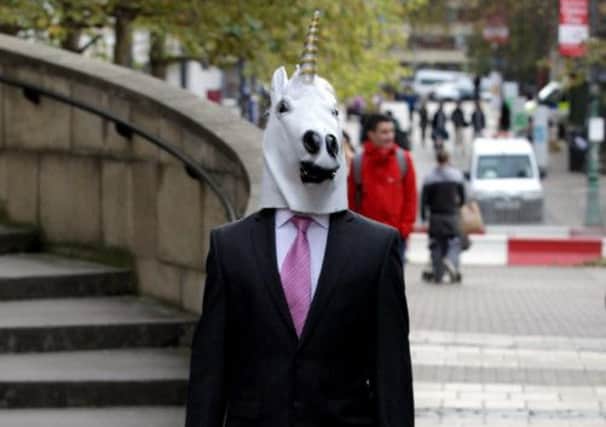 A man walking around Edinburgh in a suit, carrying a briefcase and wearing a unicorn head. Picture: HeMedia
