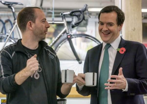 Chancellor George Osborne speaks to proprietor Jon Reid during a visit to Swift Cycles in London yesterday. Picture: Getty