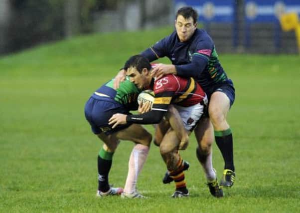 StewartsMelvilles Nick McCashin holds on grimly as he is tackled. Picture: Greg Macvean