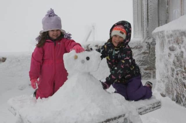 Emily Thompson and Abbey Jamieson build a snowman. Picture: Peter Jolly