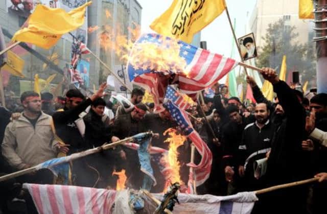 Iranians burn US flags at the former US embassy in Tehran. Hardline groups had urged high attendance at the rally. Picture: AFP/Getty