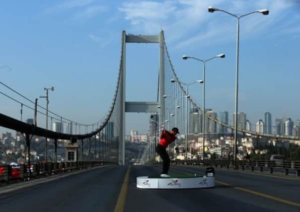 Tiger Woods makes history yesterday with the first golf shots from east to west on Istanbuls iconic Bosphorous Bridge. Picture: Getty