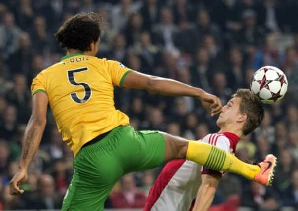Sore winner: Virgil van Dijk challenges Ajax's Joel Veltman last night. Picture: Getty