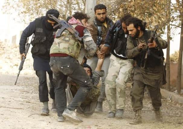 Syrian rebel fighters carry a wounded colleague away from the heavy fighting near Base 80 in Aleppo yesterday. Picture: Reuters