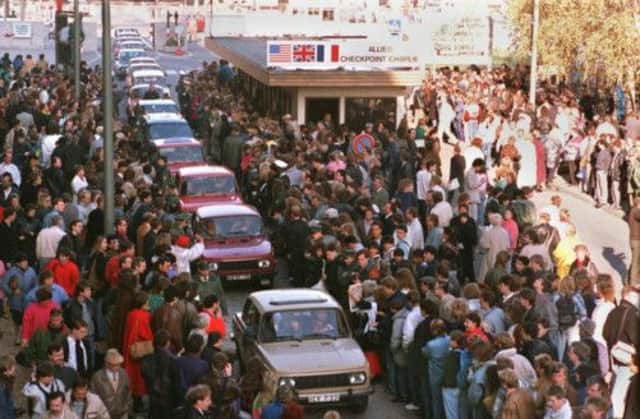Crowds stormed Checkpoint Charlie in 1989 after the East German government said it would open the Iron Curtain border. Picture: Getty