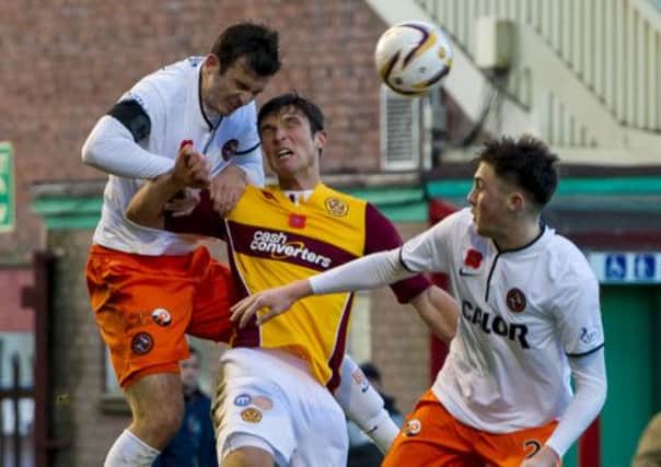 John Sutton (centre) challenges for the ball with Dundee Utd pair Gavin Gunning and John Souttar (right). Picture: SNS