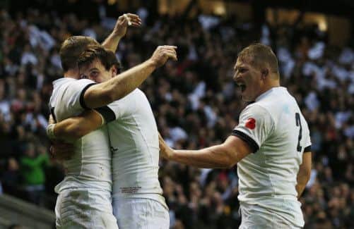 Chris Ashton, left, celebrates scoring Englands third try with Lee Dickson and Dylan Hartley. Picture: PA